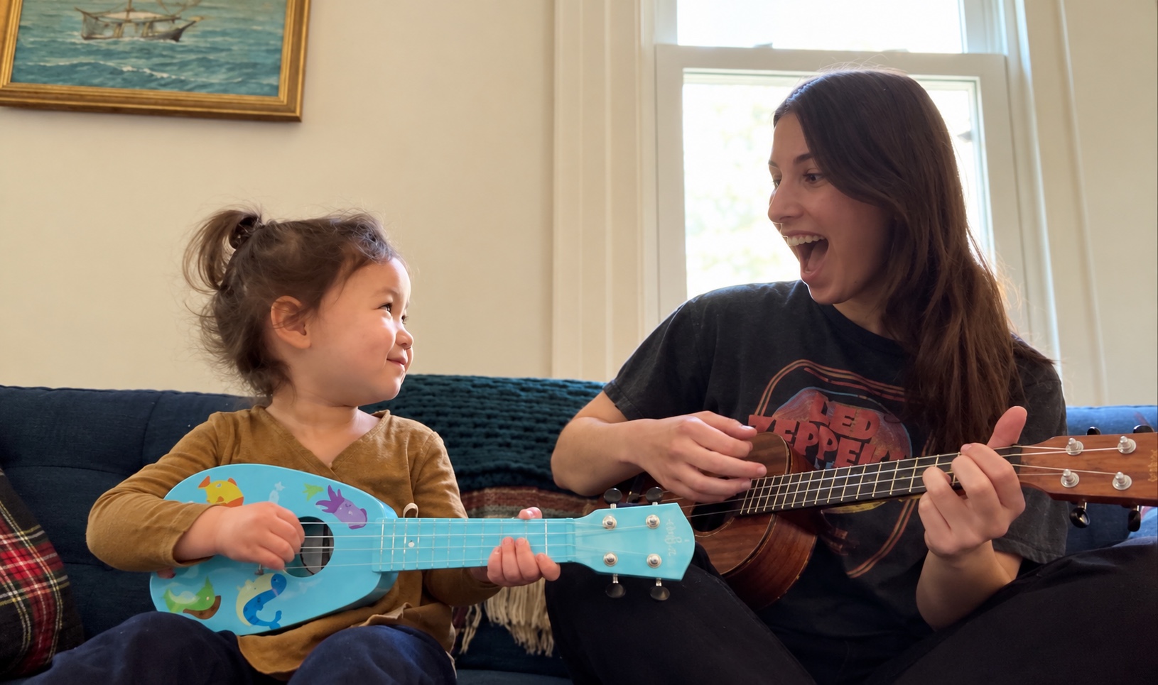 Annabelle and a young learner making music together with ukuleles